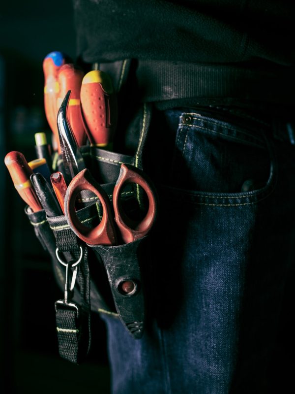 Electrician, Detail of tools belt of electrician worker at home kitchen in low key screw, low key